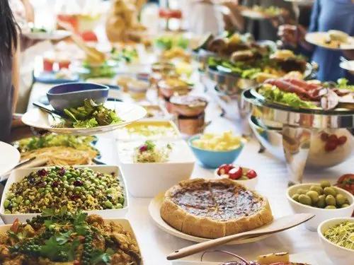 Ein Buffet mit verschiedensten Speisen in Schüsseln und auf Tellern