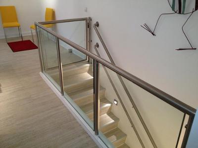 Eine Treppen mit silbernem Geländer und Sicherheitsglas