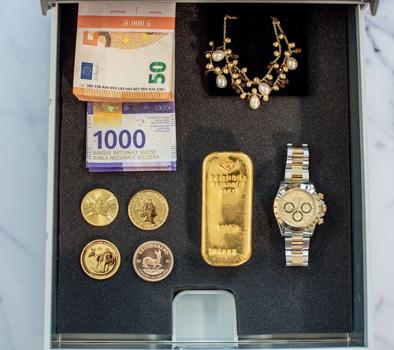 Eine Schließfachkassette gefüllt mit Schmuck, Uhren, Geld und Gold