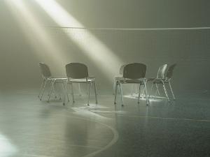 Stühle in einer Halle stehen im Kreis und Sonnenstrahlen fallen durch das Fenster