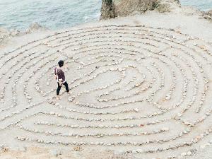 Ein Labyrinth aus Steinen und ein Mensch geht darin