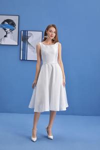 Frau im weißen Kleid vor blauer Wand