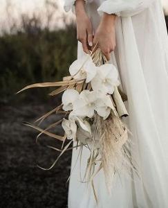 Eine Braut hält einen Brautstrauß in der Hand
