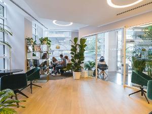 Ein helles Büro mit verschiedenen Räumen mit Glastüren und Pflanzen