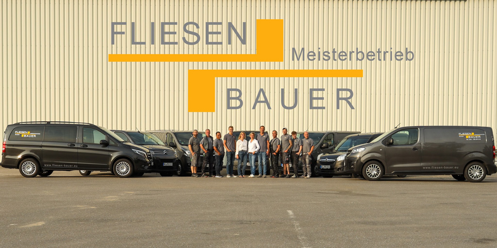 Das Team von Fliesen Bauer vor den Firmenfahrzeugen