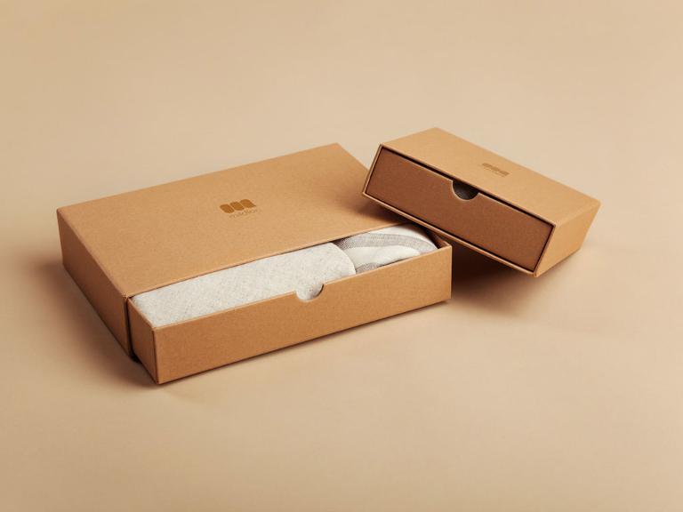 Ein Karton mit Schiebedeckel und einem weißen Textil darin
