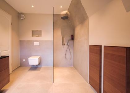 Ein Badezimmer mit Toilette und Glaswand bei der Dusche