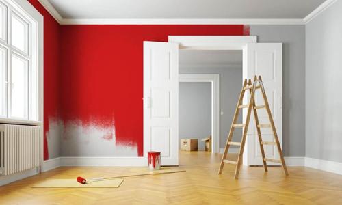 Ein Raum mit hellem Holzfußboden, einer rot gestrichenen Wand und einer Holzleiter
