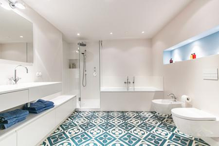 Ein Badezimmer mit weißen Fliesen und grünweißem Fußboden