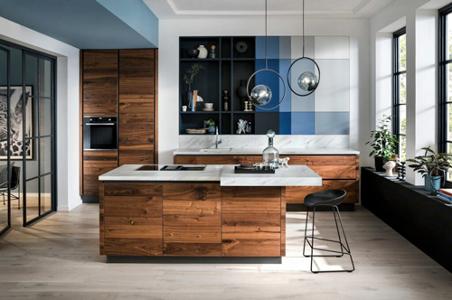 Eine Küche aus Nussbaum, weißen Arbeitsflächen und blauen Wandelementen