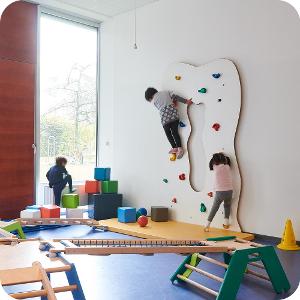 Ein Raum zum toben und spielen in der Kita kinderzimmer City Süd, mit blauem Fußboden und einer kleinen Kletterwand