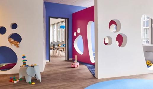 Blaue und pinke Wände in der Kita kinderzimmer Rübenkamp mit Löchern zum durchschauen und einem Holzfußboden