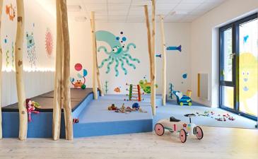 Spielzimmer von Kita kinderzimmer Alsterberg als Unterwasserwelt mit blauer Tobematte.