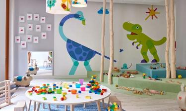 Spielzimmer der Kita kinderzimmer ConventParc, mit bunten Dinosauriern die an die Wände gemalt sind und buntem Spielzeug auf einem Holztisch