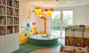Spielzimmer mit Bücherregalen und Kuschelecke von Kita Kinderzimmer Süderfeldpark.