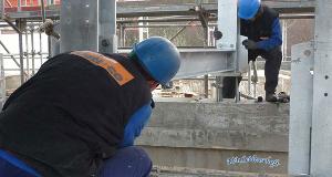 Zwei Männer arbeiten an einer Stahlkonstruktion auf einer Baustelle