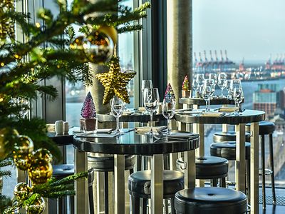  Gedekcter Tische vor Hafenpanorama, im Vordergrund ein Weihnachtsbaum