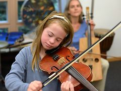  Therapiesitzung: Mädchen spielt auf der Geige begleitet von der Therapeutin auf dem Kontrabass.