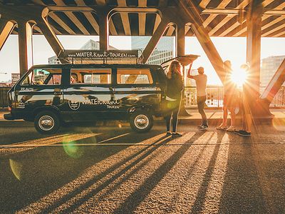  Ein VW Bulli auf einer Brücke, Sonnenschein im Hintergrund