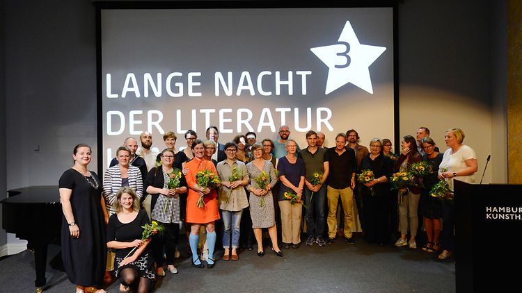 Die Preisträger des Buchhandlungspreises mit Blumensträußen auf der Bühne