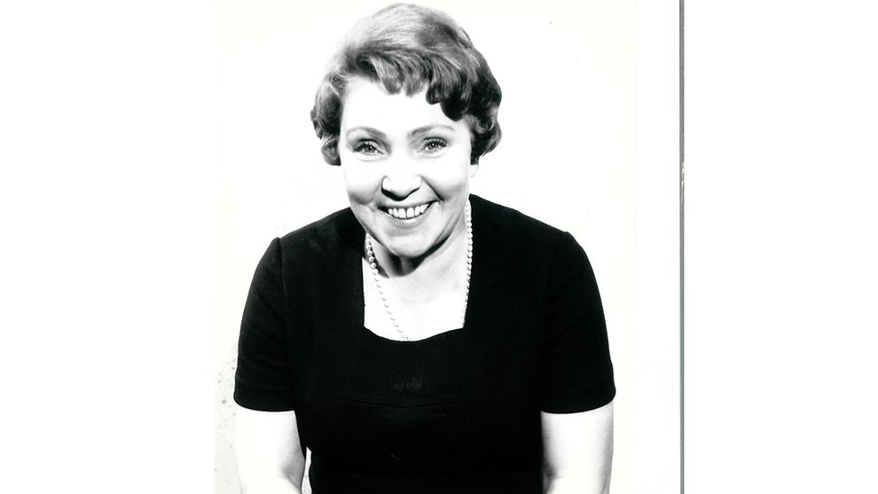 Schwarzweiß-Porträt einer freundlichen Dame mit Perlenkette