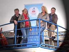  Vier Autoren des Hamburger VorleseVergnügens stützen sich auf einer Schiffs-Balustrade ab.