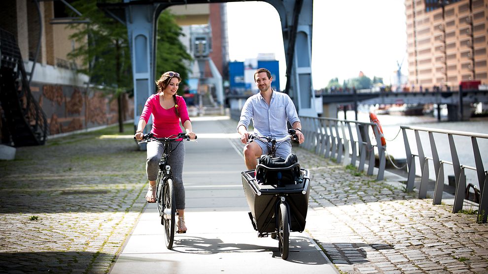 Eine Frau und ein Mann fahren Fahrrad in der Sonne 
