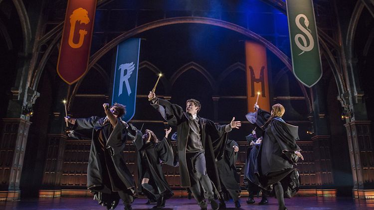  Szene aus "Harry Potter und das verwunschene Kind": Junge Zauberer in Umhängen halten ihre Zauberstäbe in die Luft