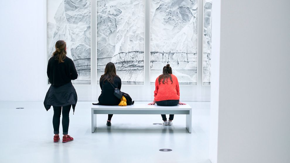 Drei Frauen in Rückenansicht in einem Ausstellungsraum vor einem Bild