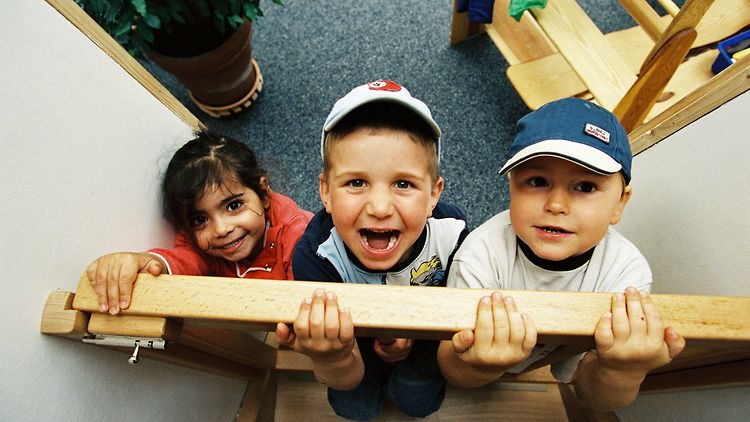  Drei Kinder halten sich an einem Holzrahmen fest (Foto: Meyborg)