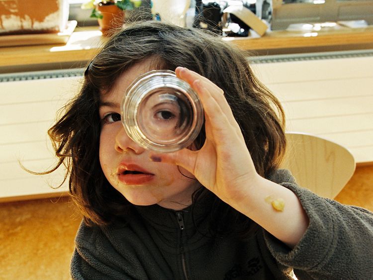  Kita: Ein Kind schaut neugierig durch ein Glas