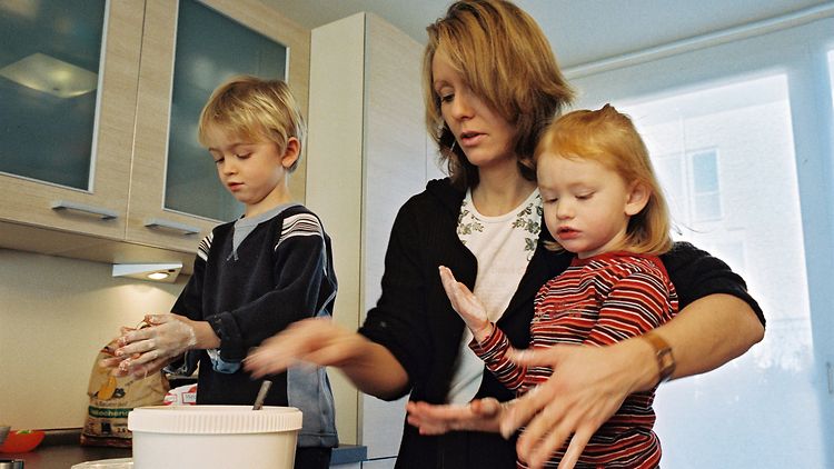  Mutter mit zwei Kindern in der Küche