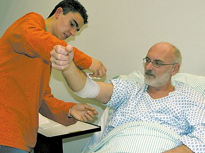  Ein junger Mann verbindet einen Patienten. Foto: Erich Roos