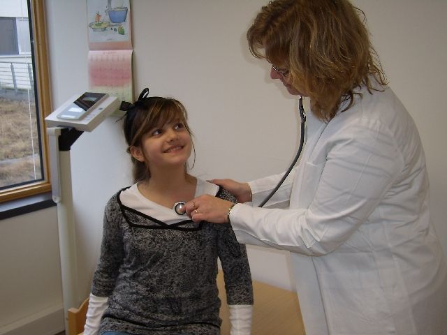 Kind lässt sich von einer Ärztin mit einem Stethoskop untersuchen