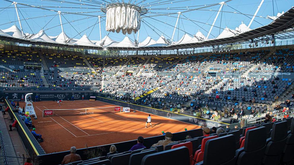 Das Tennisstadion am Rothenbaum. Auf dem roten Sandplatz stehen zwei Tennisspieler. Auf den Tribünen sitzen viele Zuschauer.