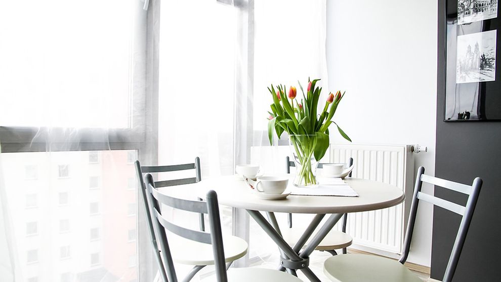  Tisch mit Stühlen und Vase mit Tulpen