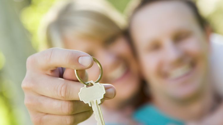  Ein Mann und eine Frau halten einen Wohnungsschlüssel