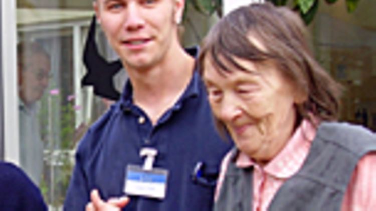 Ein Pfleger betreut eine alte Dame