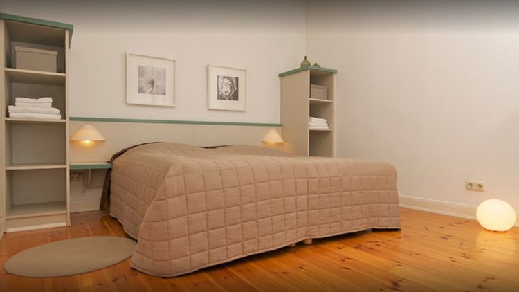  Zimmer mit beige bezogenem Bett