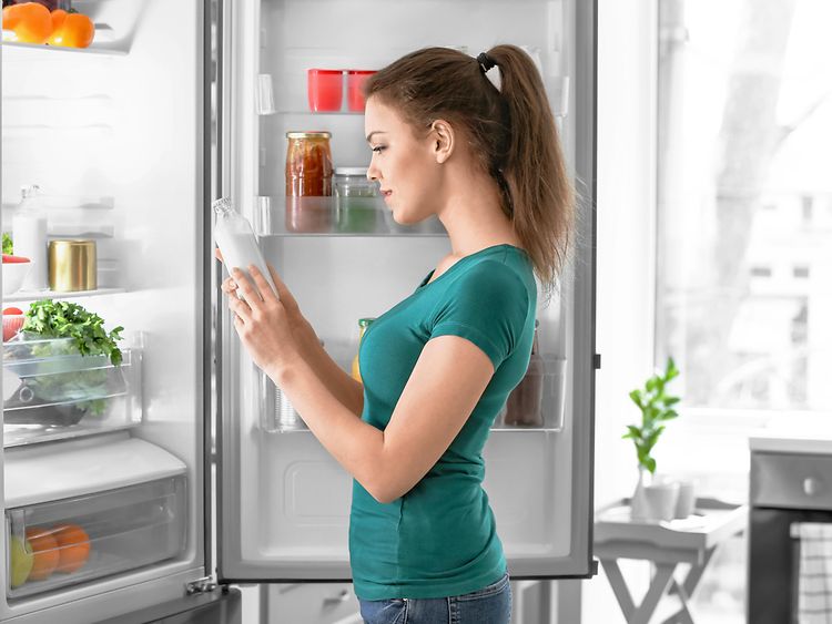  Woman taking food out of fridge at home