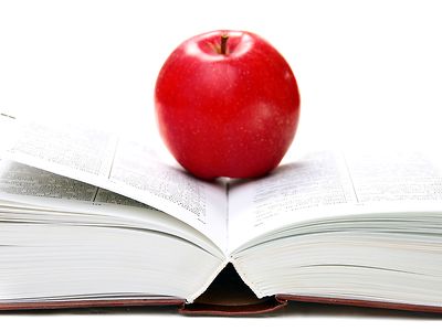  aufgeschlagenes Buch mit rotem Apfel