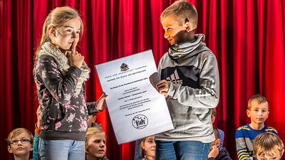  Zwei Schüler*innen der Klasse 3e halten die Urkunde für den 1. Platz in den Händen.