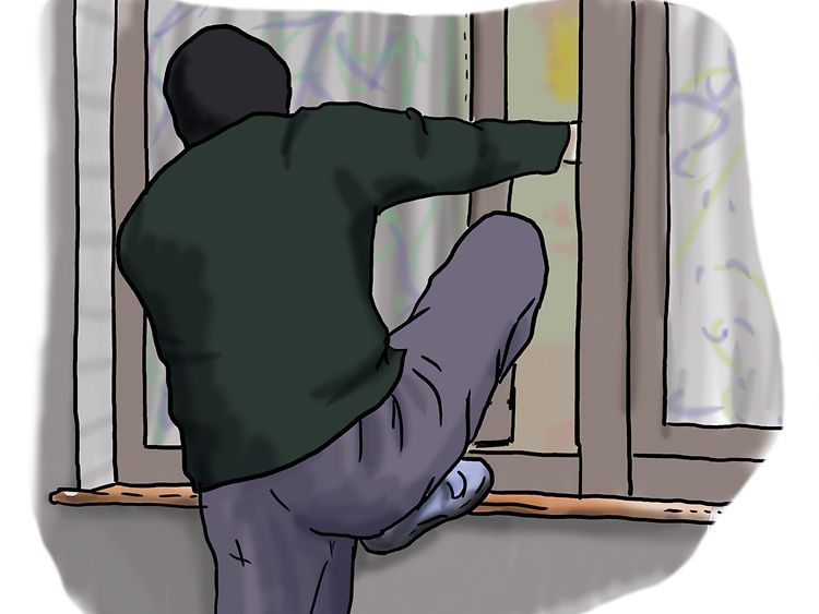  Ein Einbrecher steigt durch ein Fenster