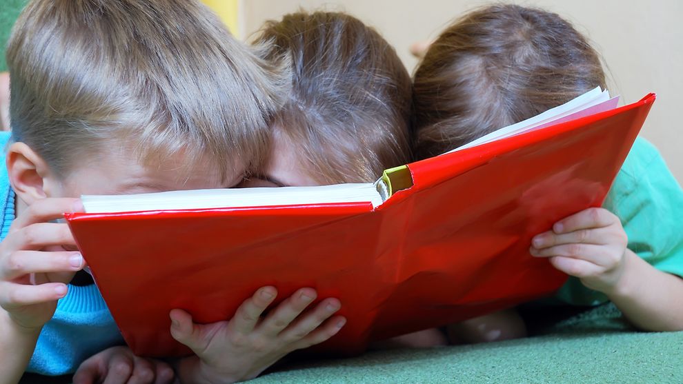 Lernende Kinder in der Vorschule - Kinder schauen in ein Buch