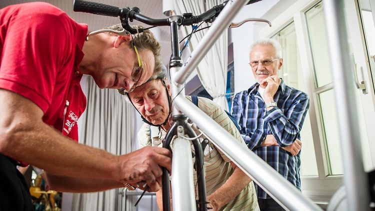  Offene Fahrradwerkstatt des Repair Cafés Sasel - Drei Männer begutachten ein Fahrrad
