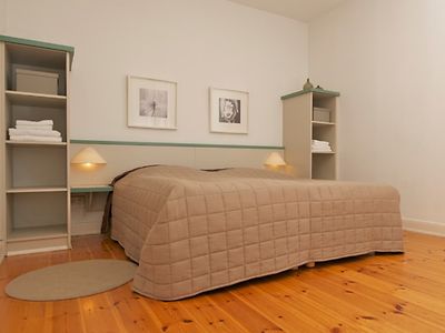  Großes Bett mit grauer Decke in einem Hotelzimmer