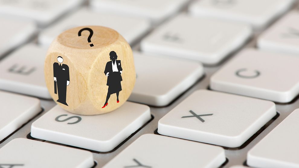 Tastatur auf der ein Holzwürfel mit einem weiblichen und männlichen Bild liegt