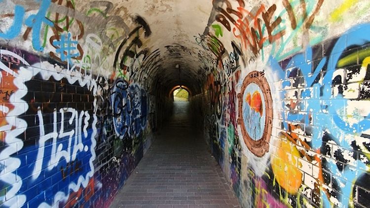  Tunnel mit besprühten Graffitiwänden.