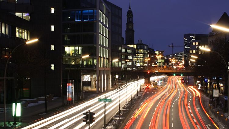  Zwei Hauptverkehrsstraßen bei Nacht mit Langzeit-Lichteffekt der Rücklichter und Scheinwerfer der Autos.