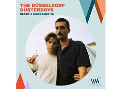  Die Band The Düsseldorf Düsterboys, ein Mann im weißen T-Shirt Arm in Arm mit einem Mann im schwarzen Polohemd